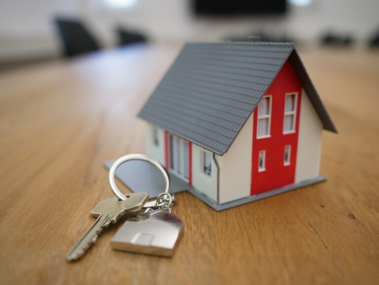 Pessoa analisando contrato de financiamento imobiliário ao lado das chaves de uma casa