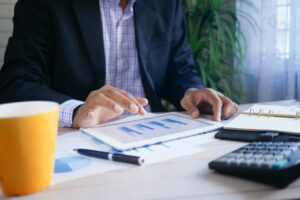 Pessoa analisando fatura e documentos financeiros à mesa