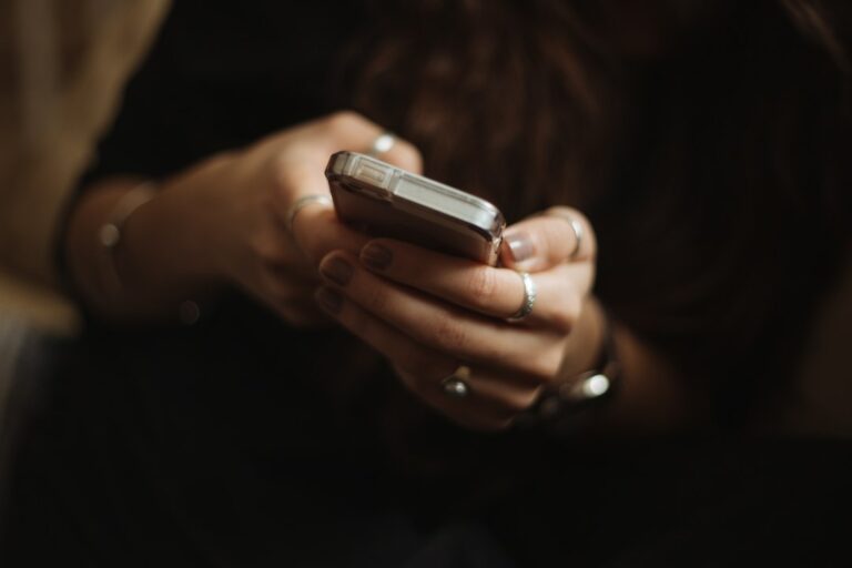 Pessoa lendo mensagem no celular sobre suposto processo judicial