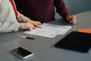 Pessoa analisando contrato de financiamento e documentos judiciais sobre a mesa