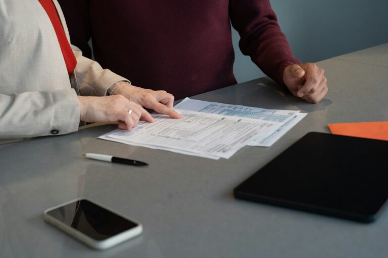 Pessoa analisando contrato de financiamento e documentos judiciais sobre a mesa