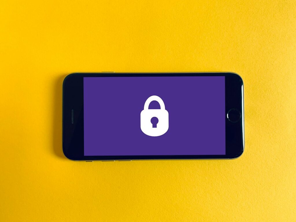 Pessoa segurando celular com aplicativo bancário bloqueado por segurança
