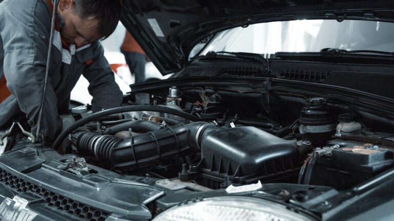 Mecânico inspecionando o motor de um carro em oficina